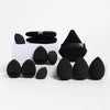 A set of twelve black all-purpose makeup sponges arranged on a white surface.