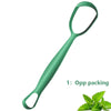 Raspador de lengua de acero inoxidable verde con una ramita de hojas de menta.