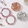 A set of vintage rose design double-sided pocket makeup mirrors in pink and silver tones.