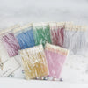 A collection of crystal lip brush kits with lash spoolies in various shades of pink, purple, blue, and green.