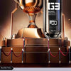 A bronze trophy stands next to a black electric nose and ear hair trimmer with a rounded knife cutter head.