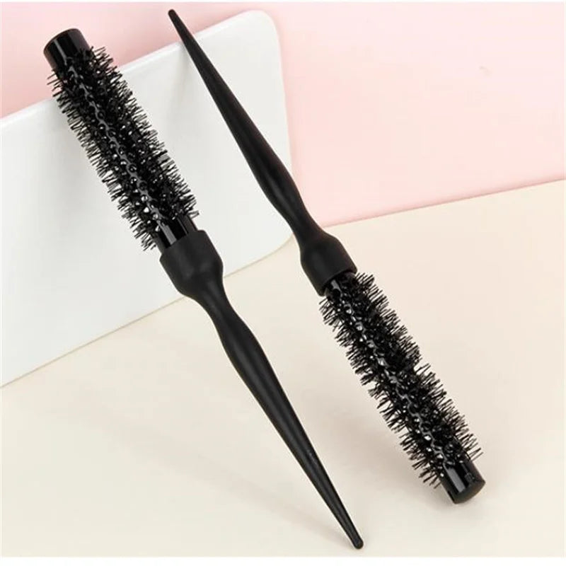 A black professional curly round hair comb with elastic teeth is shown on a light background.