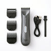 A gray electric body and pubic hair trimmer with multiple guard attachments and a charging cable.