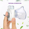 A hand holds a portable nebulizer device with a clear mouthpiece and a white body, demonstrating its use for atomization.