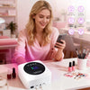 Una mujer está usando una lámpara de curado de esmalte UV/LED blanca sobre una mesa, con varios accesorios cercanos.