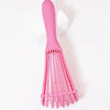 A pink adjustable detangling hair brush with multiple flexible bristles is shown against a white background.