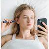 A woman is using a 6-axis gyroscope ear cleaning device while lying in bed.