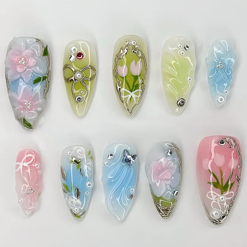 A collection of 24 press-on almond nails featuring various 3D floral and butterfly designs in pastel and translucent colors.