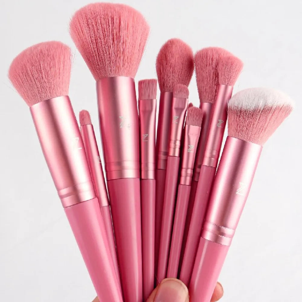 A collection of pink makeup brushes with fluffy bristles displayed against a light background.