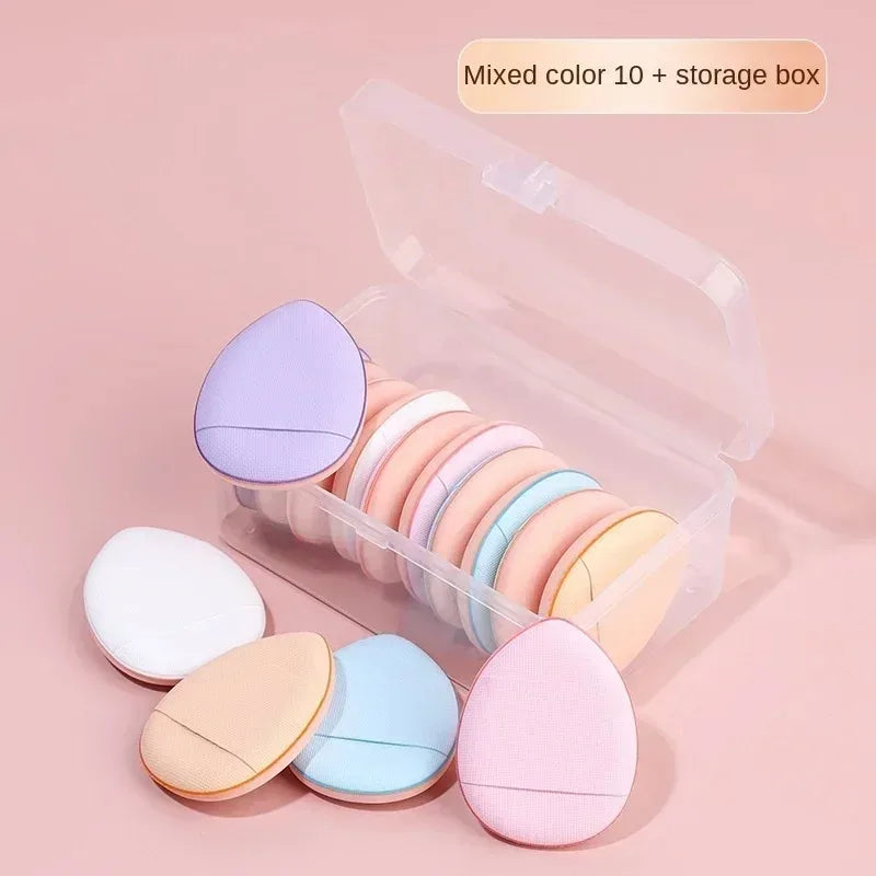 Une boîte de rangement contenant dix mini éponges de fond de teint dans différentes nuances de rose et pêche.