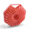 A pink silicone exfoliating shower scrub brush with a textured, fan-like surface.