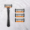 A precision multi-blade shaver with three interchangeable heads floating in clear water.