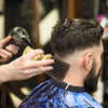A barber is using a comb to style a haircut on a man's head.