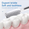 A white bristled toothbrush head is shown cleaning a white tooth model.