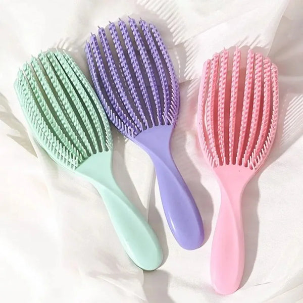 Three plastic hair brushes in shades of green, purple, and pink are displayed on a white background.