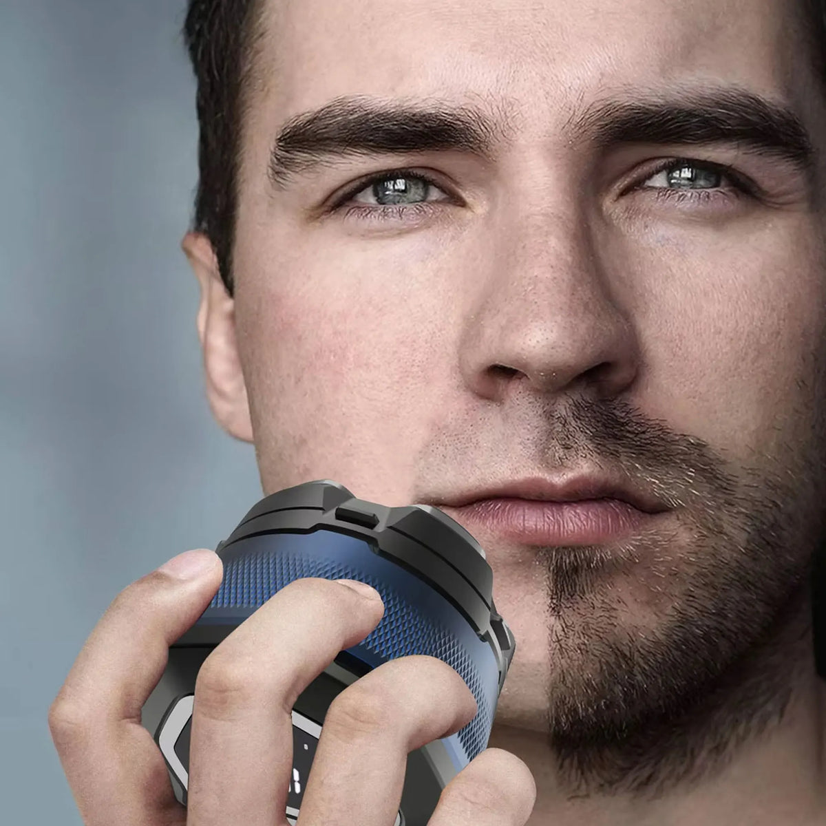 A man is holding a precision electric shaver with magnetic charging in his hand.