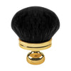 Une grande brosse de maquillage en poudre noire avec une base et une poignée de couleur or.