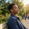A young man wearing silicone noise-cancelling earplugs outdoors in natural light.