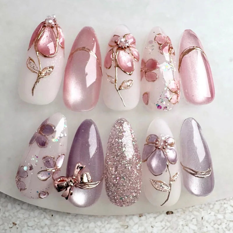 Un ensemble de 24 ongles press-on roses français à amande avec paillettes et motifs floraux.