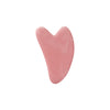 A pink, heart-shaped resin facial massage roller.