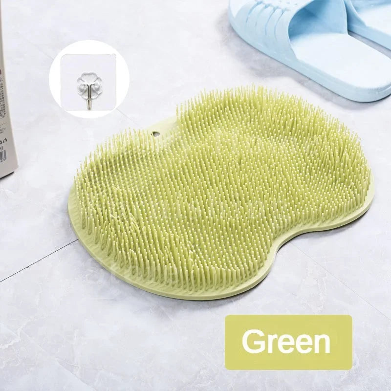 A light green silicone foot scrubber with numerous textured bristles is shown on a white surface.