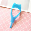 Outil applicateur de mascara en plastique bleu clair posé sur une surface à grille rose.