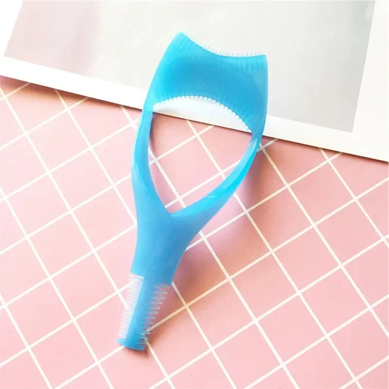 Outil applicateur de mascara en plastique bleu clair posé sur une surface à grille rose.
