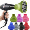 A hand holds a black hair dryer with a silicone diffuser cover in various colors, including green, purple, pink, and red.