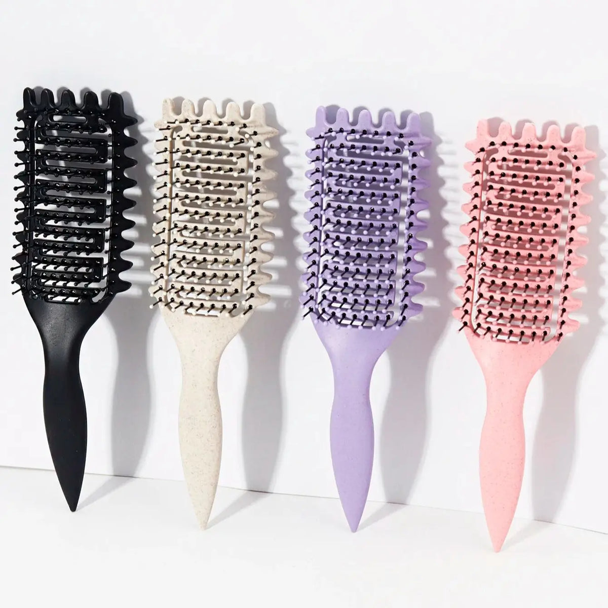 Une rangée de cinq peignes pour cheveux bouclés professionnels noirs, beige, violet et rose.