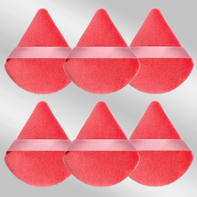 Un ensemble de six éponges de maquillage triangulaires roses avec des accents de ruban rose.
