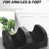 Black multi function massager for arm, leg, and foot resting on a striped surface.