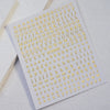 A sheet of laser gold and silver 3D alphabet nail art stickers featuring various letters.