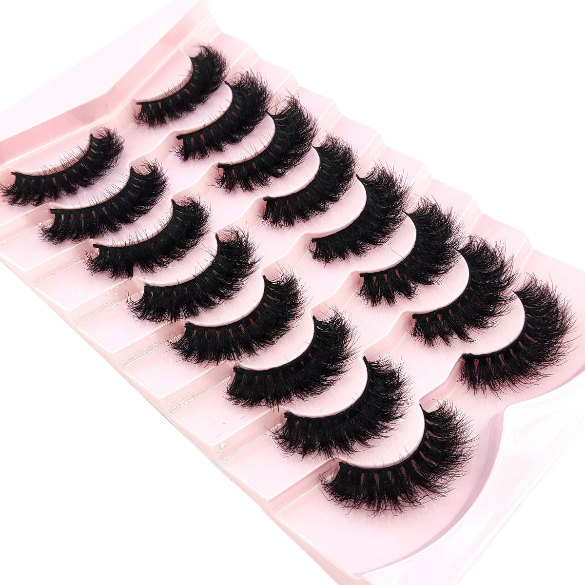 A pink tray holds a set of natural mink striped false eyelash extensions.