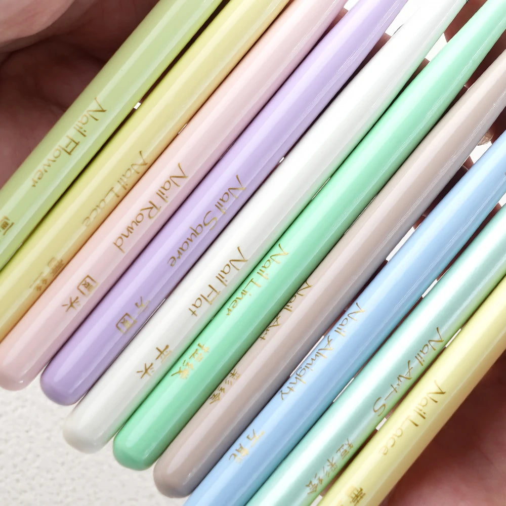 A close-up of a set of professional nail art brushes in various pastel shades arranged diagonally.