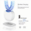 A white ultrasonic electric toothbrush charging base with a blue brush head and a flat charging adapter.
