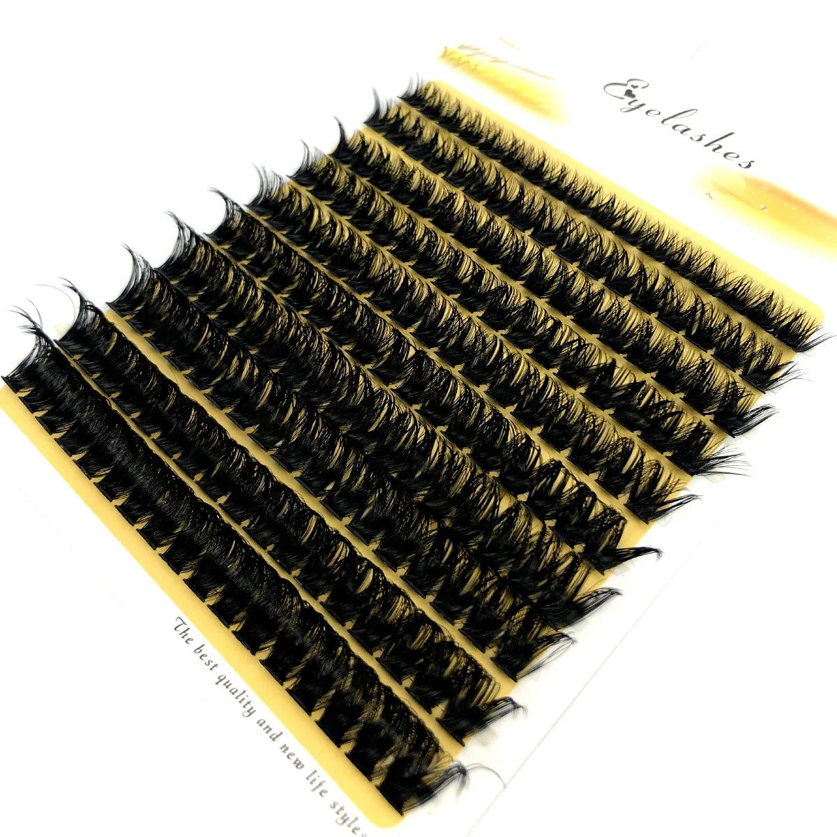 A fan-shaped cluster of black mink eyelashes displayed on a yellow background.