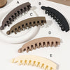 Five different colored banana hair clips shown in various angles and colors.