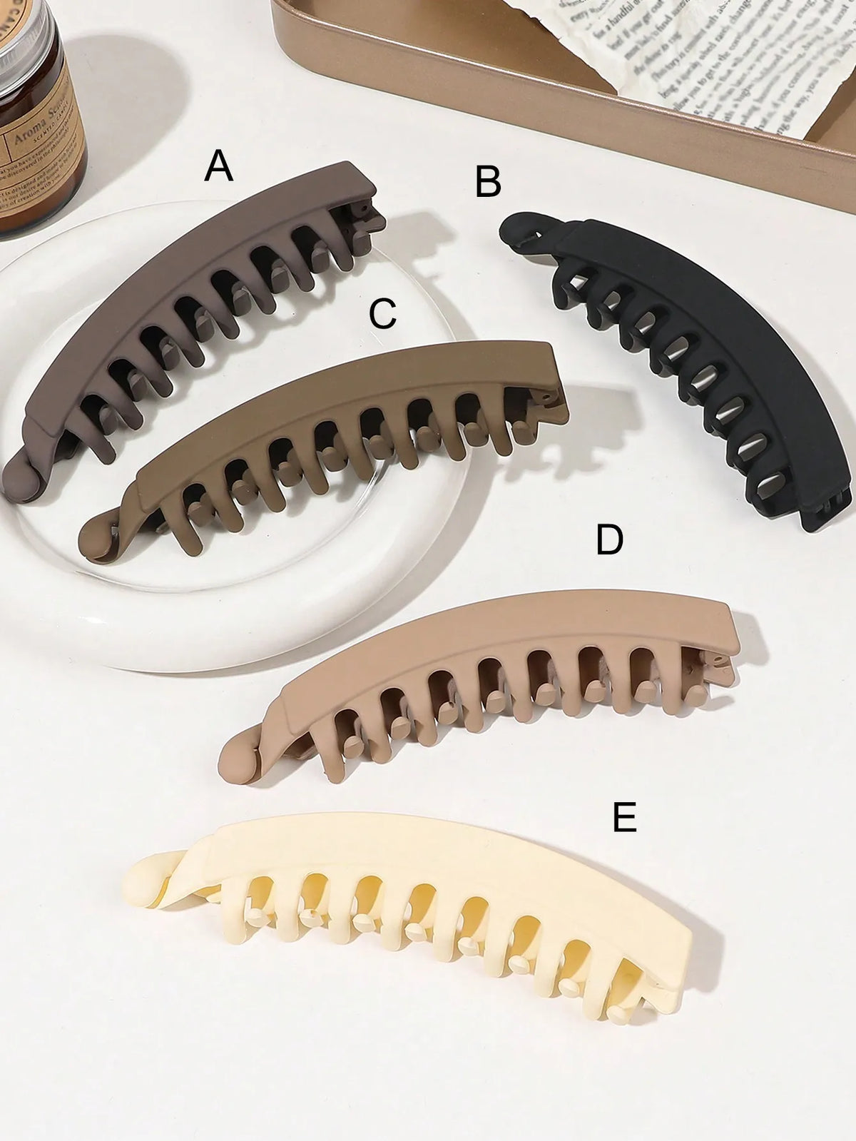 Five different colored banana hair clips shown in various angles and colors.