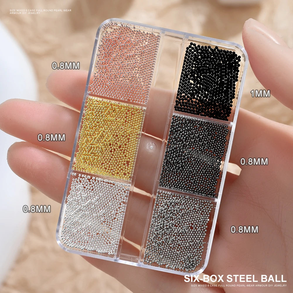 A clear box of mixed stainless steel beads in various colors and sizes for nail art decorations