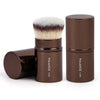 A set of two brown makeup brushes with fluffy bristles and dark handles displayed next to their packaging.