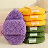 A stack of purple and green exfoliating cleansing sponges for blackhead removal
