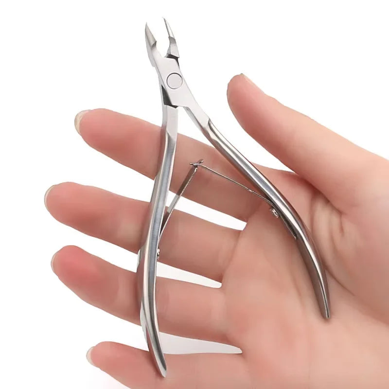 A hand is holding a pair of professional stainless steel cuticle nail nippers.
