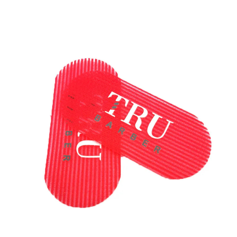Un ensemble d'outils pour tenir et coiffer les cheveux en silicone rouge, marqué TRU BARBER.