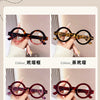 A display of various colored round acetate reading glasses, including brown, amber, and red tones.