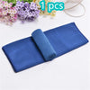 A rolled blue microfiber sport towel is shown next to some flowers and a white cord.