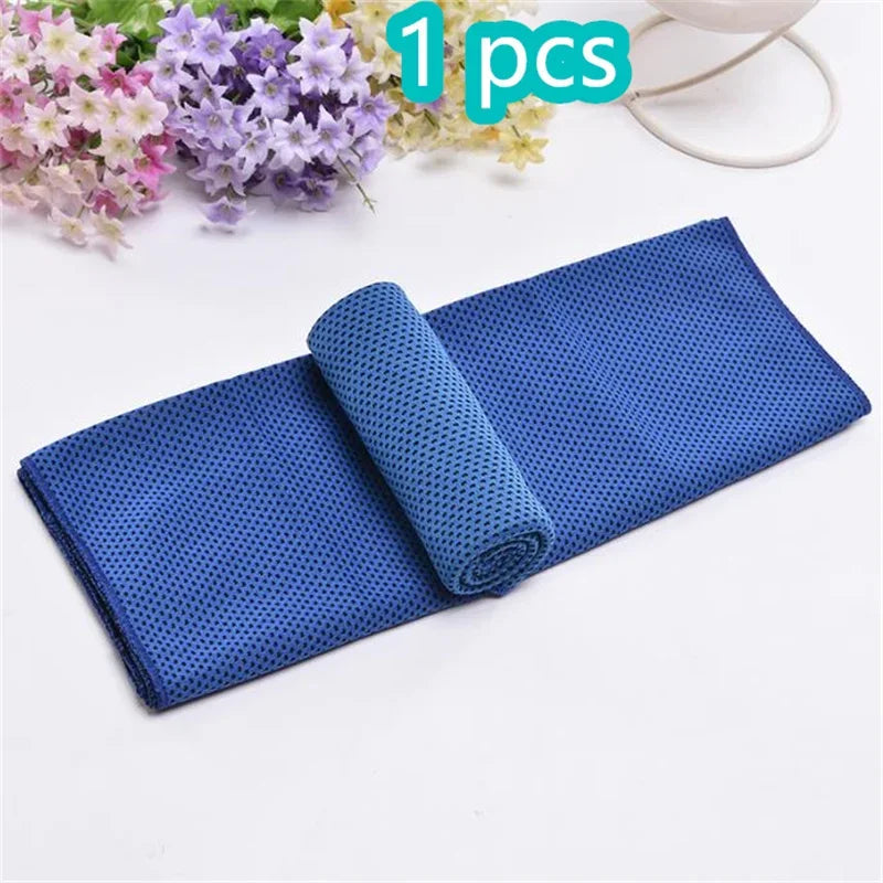 A rolled blue microfiber sport towel is shown next to some flowers and a white cord.