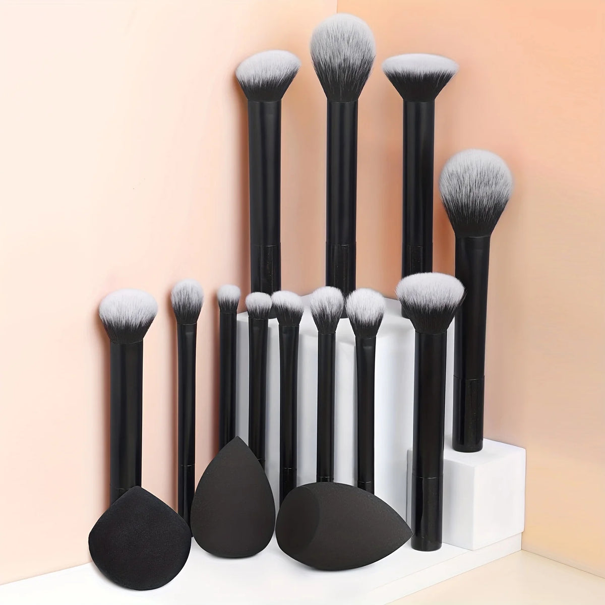 Una colección de doce brochas de maquillaje profesionales en varios tamaños y tonos, mostradas en un soporte blanco.