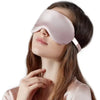 A woman is wearing a pink double-sided silk eye mask while relaxing.