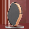 A portable glass foot file and callus remover tool with a black surface and rose gold accents resting on a gray base.