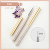 A set of professional nail art brushes with gold and pink handles, including a fine point brush.